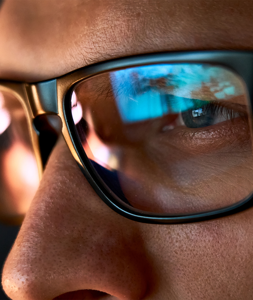 Photo of a computer screen reflected in the lens of a man's eye glasses