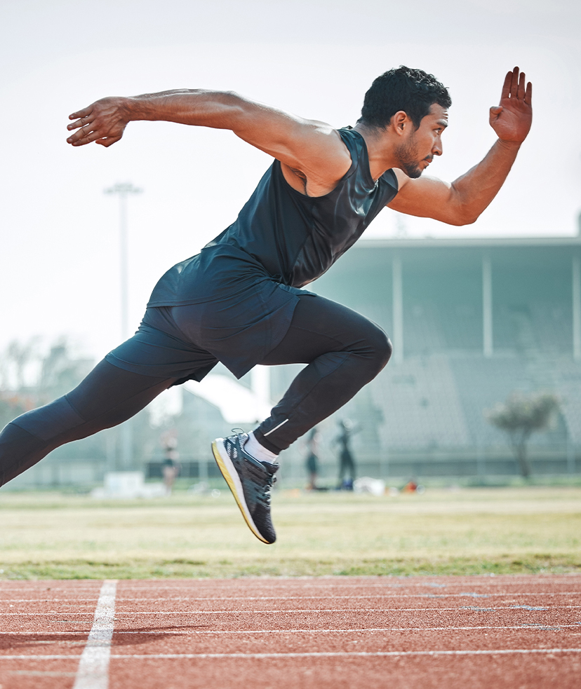 Photo of a man sprinting outside on a track