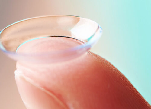 Photo of a finger holding up a contact lens